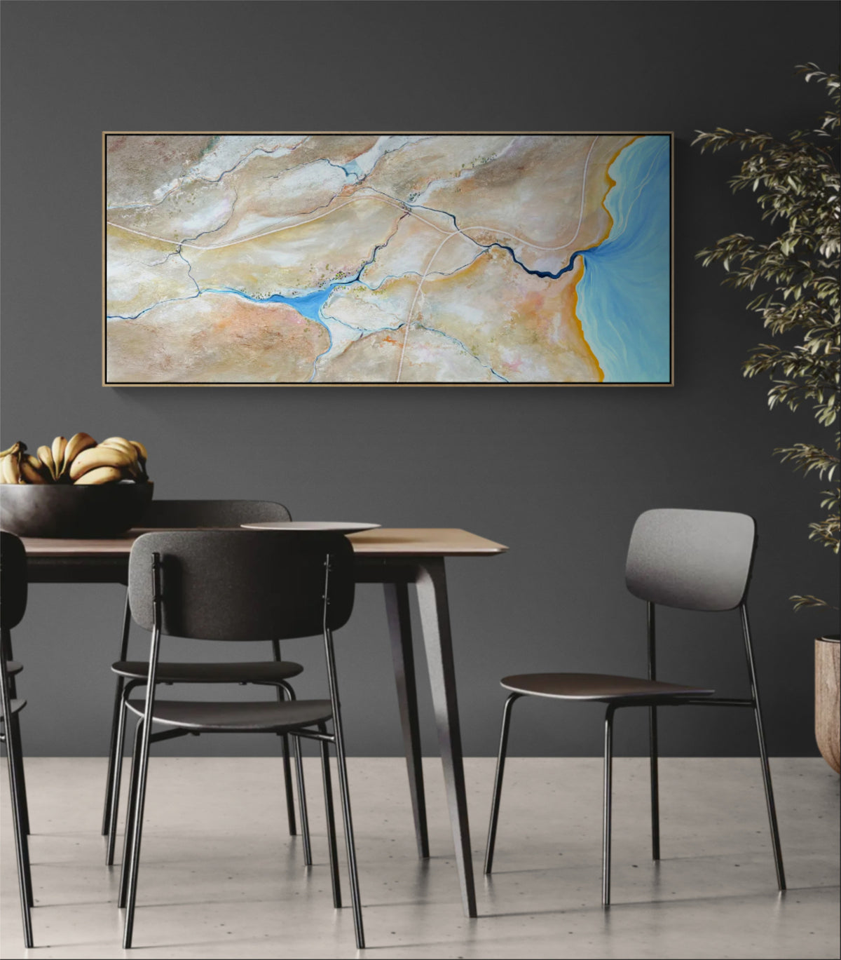 A large framed abstract landscape painting hangs on a dark gray wall above a dining table with chairs in a modern dining room setting.