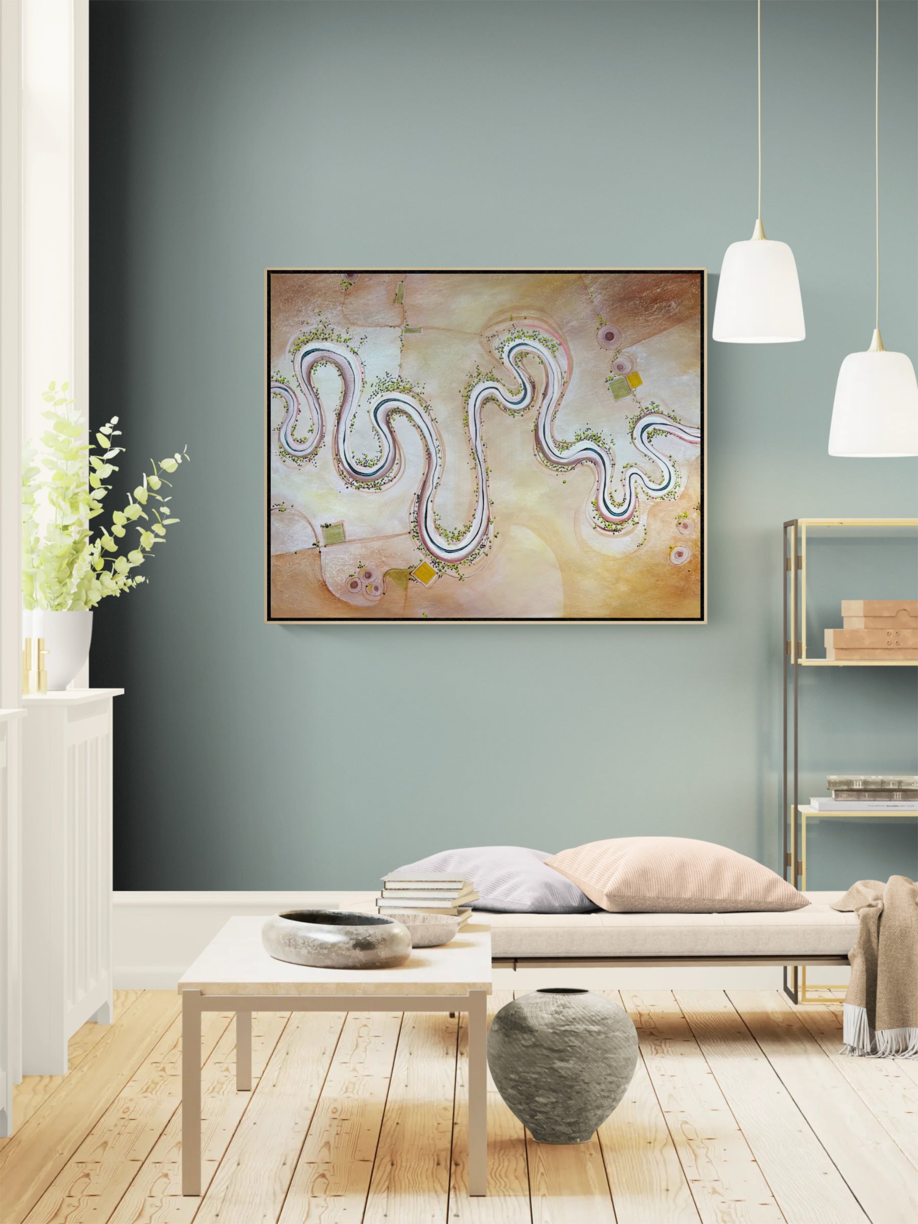 Abstract framed wall art hanging on a muted blue-gray wall in a styled living room with a bench, pillows, table, pendant lights, and wood flooring.