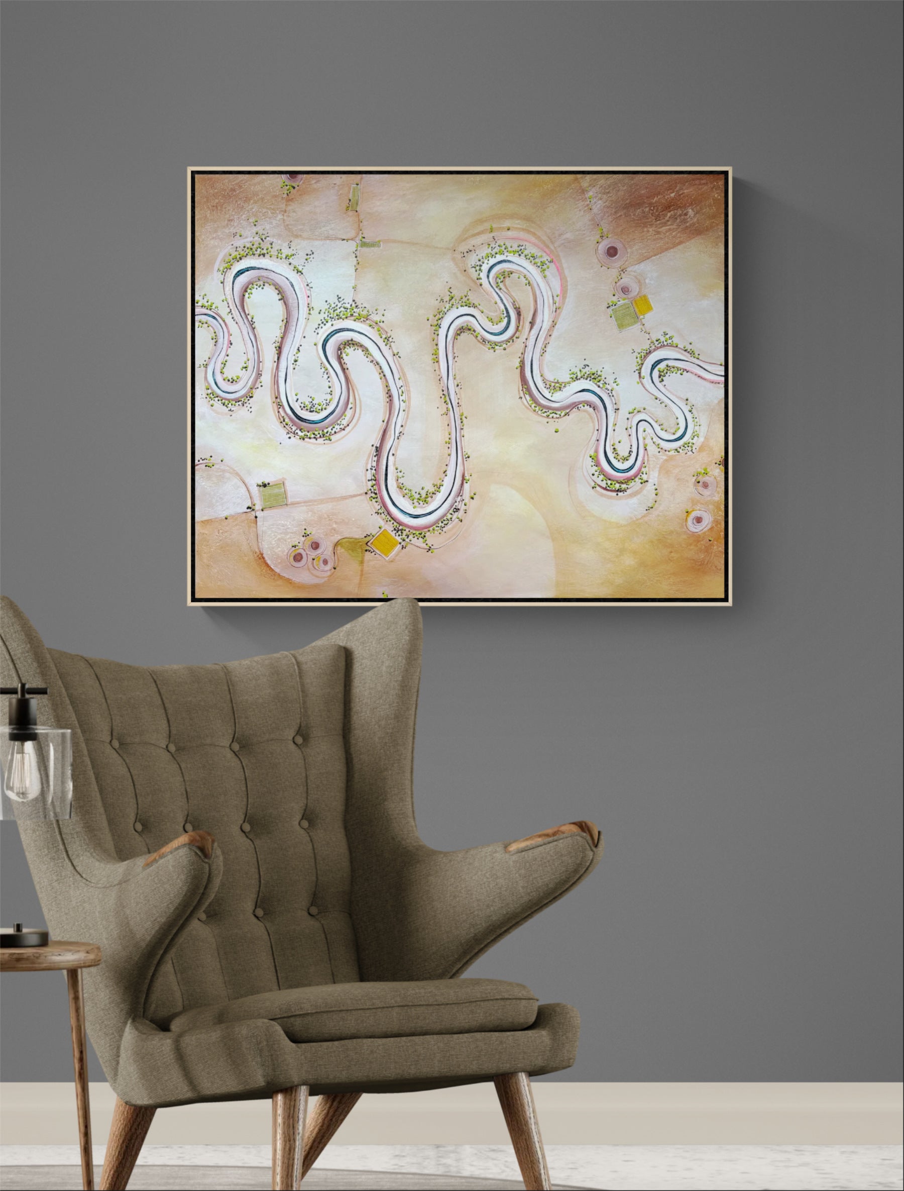 An abstract framed wall textured original abstract landscape featuring wavy multicolored lines on a warm beige and cream background, displayed on a dark gray wall above a tufted olive green armchair.