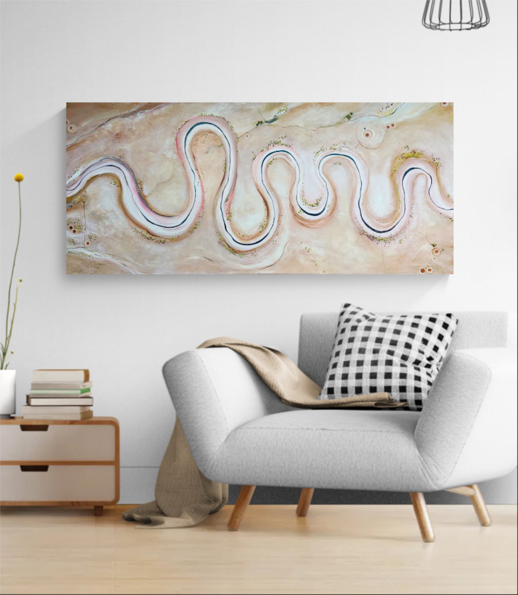 A wide rectangular abstract wall art piece with flowing wavy lines in cream, beige, white, and soft pink tones, displayed above a light gray armchair in a styled living room setting.