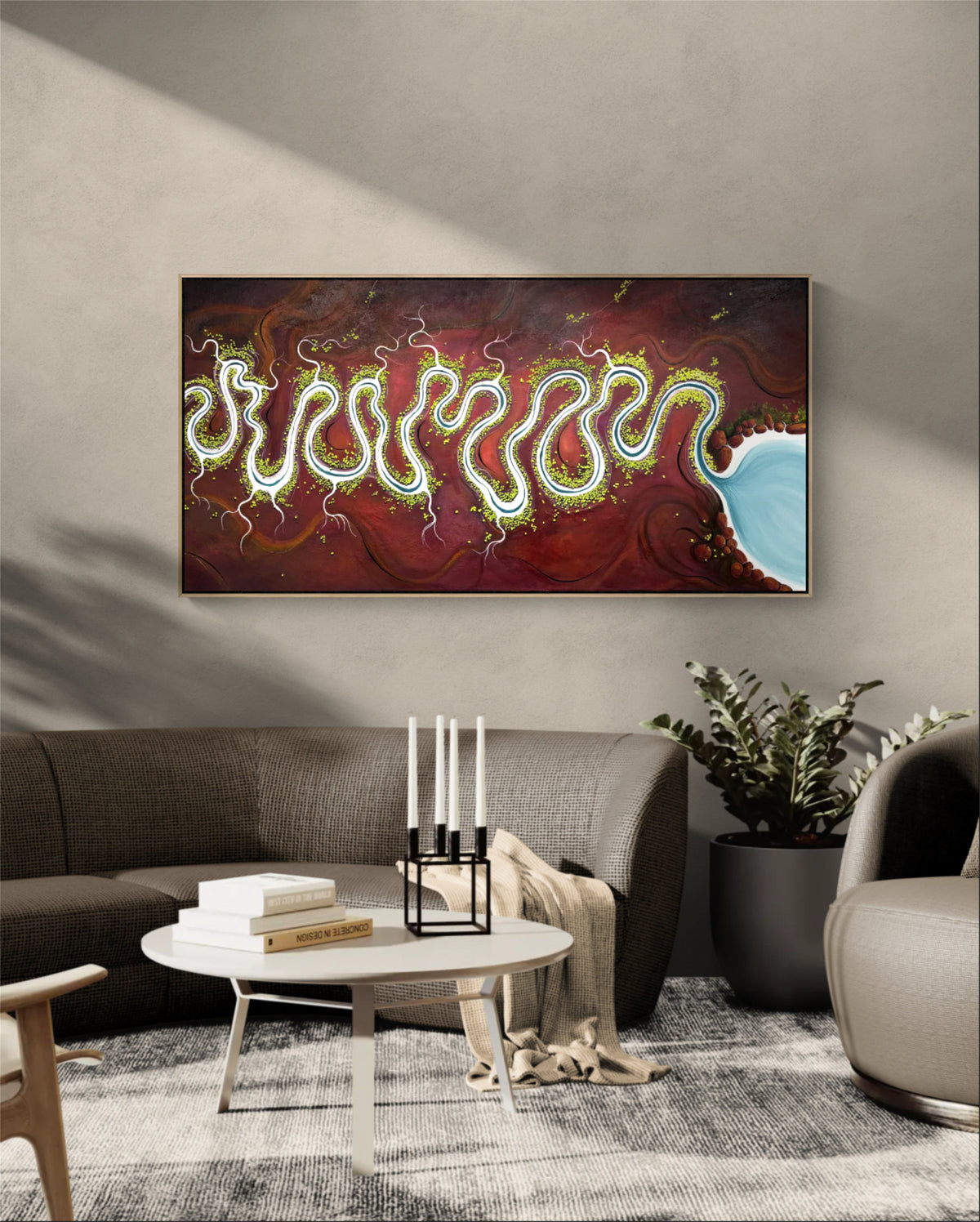 A framed abstract original landscape  hangs above a grey sofa in a modern living room. The artwork features a dark maroon and red background with flowing neon-like green and yellow lines and a light blue shape on the right.