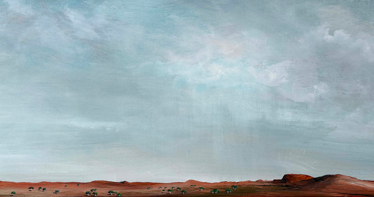 A landscape painting depicting a vast, cloudy sky in shades of blue-gray and white, with a reddish-brown desert horizon and small figures of people and camels in the distance.